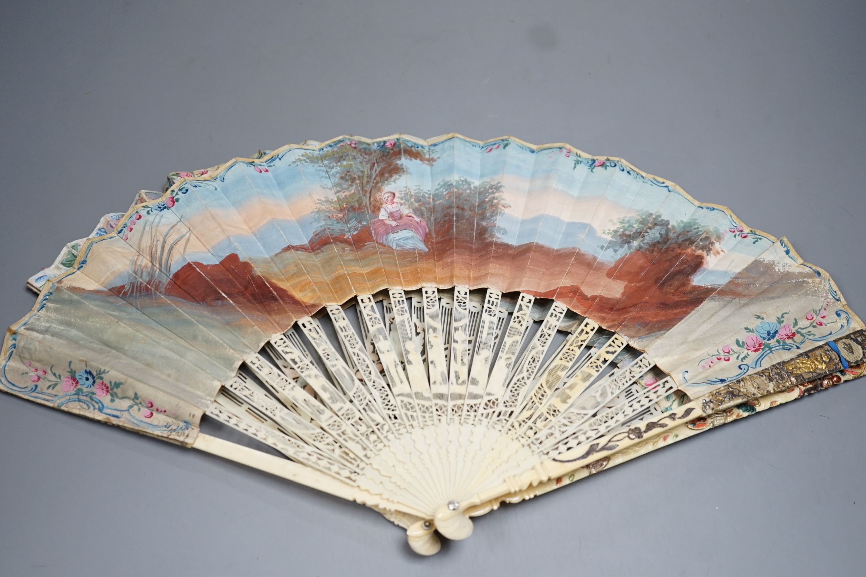 Two late 18th/early 19th century French gilded and silvered ivory and painted paper leaf fans